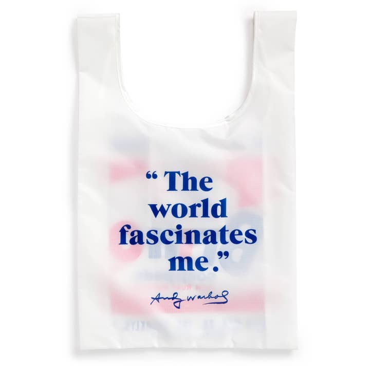 White reusable tote bag featuring the phrase 'The world fascinates me.' in blue text, attributed to Andy Warhol's signature. The design is minimal with Warhol's famous quote printed in bold.