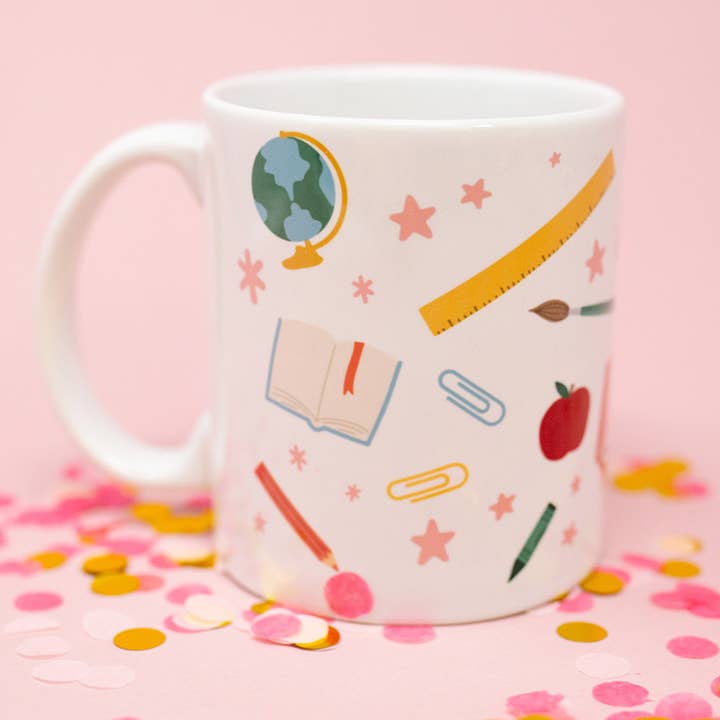 Teacher mug with classroom icons featuring illustrations of a globe, apple, ruler, book, and pencil on a white background.