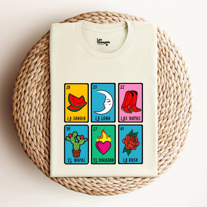 A colorful Mexican Lotería t-shirt featuring iconic images from the traditional game, including vibrant illustrations and playful symbols. The shirt is made from soft cotton fabric, perfect for casual wear, and showcases a unique design that celebrates Mexican culture.