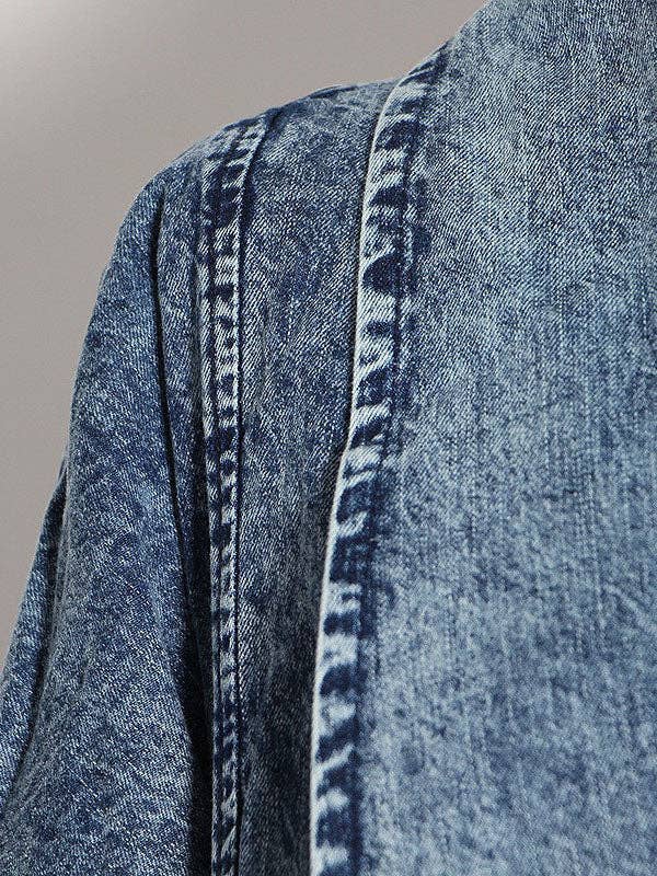Closeup of oversized denim jacket right shoulder showcasing an acid wash color.