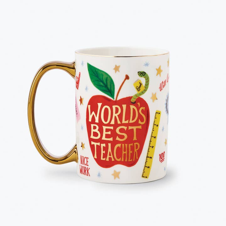 White mug with an apple design and gold-tone handle, featuring the phrase "Best Teacher in the World with handle on left side.