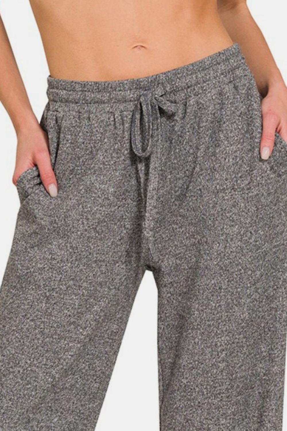 Close up of drawstring wide-leg pants with side pockets, featuring a comfortable and stylish design, perfect for casual wear or lounging, made from a soft and stretchy fabric blend.