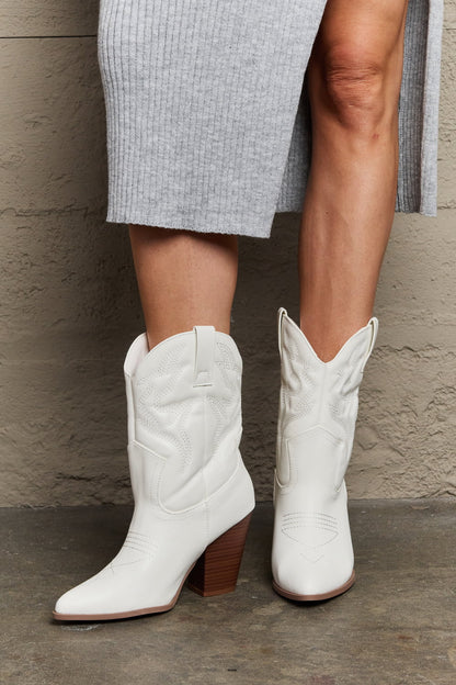 Model wearing White mid-calf cowboy boots featuring a low heel and classic western-inspired design. These boots offer a perfect blend of style and comfort, adding a bold yet versatile touch to any outfit.