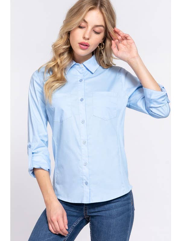 Closeup frontview of a woman wearing a light blue button-down shirt with 3/4 roll-up sleeves and skinny jeans, showcasing a casual yet polished look perfect for both work and casual settings. 