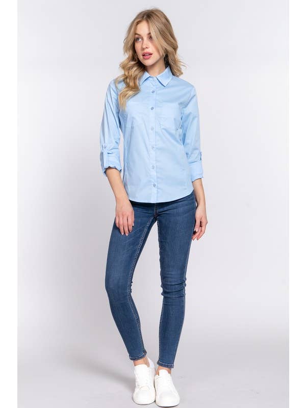 Woman wearing a light blue button-down shirt with 3/4 roll-up sleeves and skinny jeans, showcasing a casual yet polished look perfect for both work and casual settings.