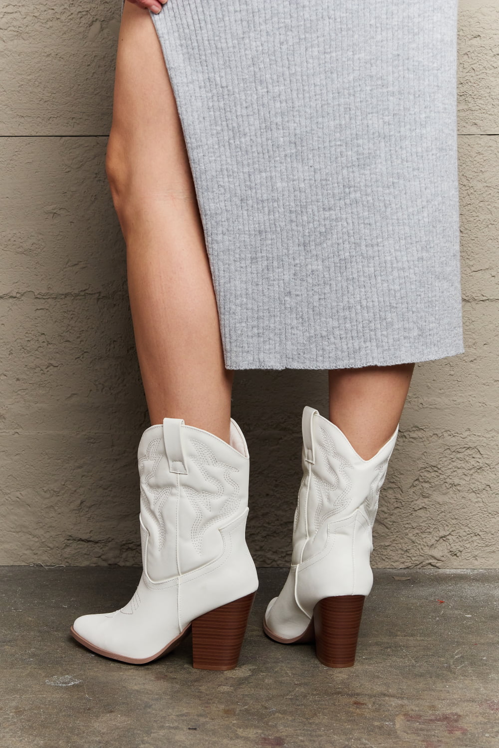 Back view of model wearing White mid-calf cowboy boots featuring a low heel and classic western-inspired design. These boots offer a perfect blend of style and comfort, adding a bold yet versatile touch to any outfit.