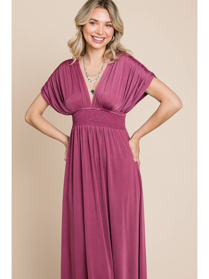 Woman wearing grape, shirred empire waist maxi dress, front view, smiling with hands on hips.