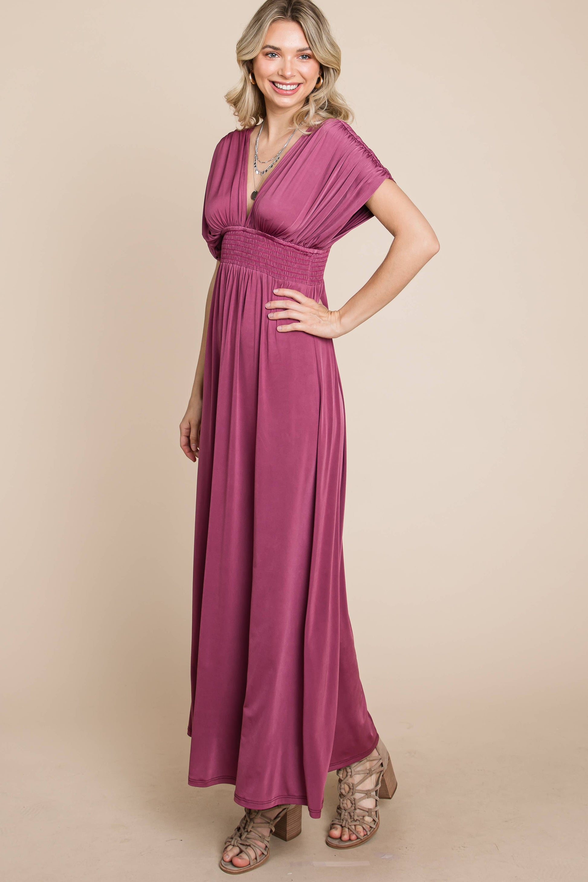 Full body side angle view of woman wearing flowy, grape maxi.