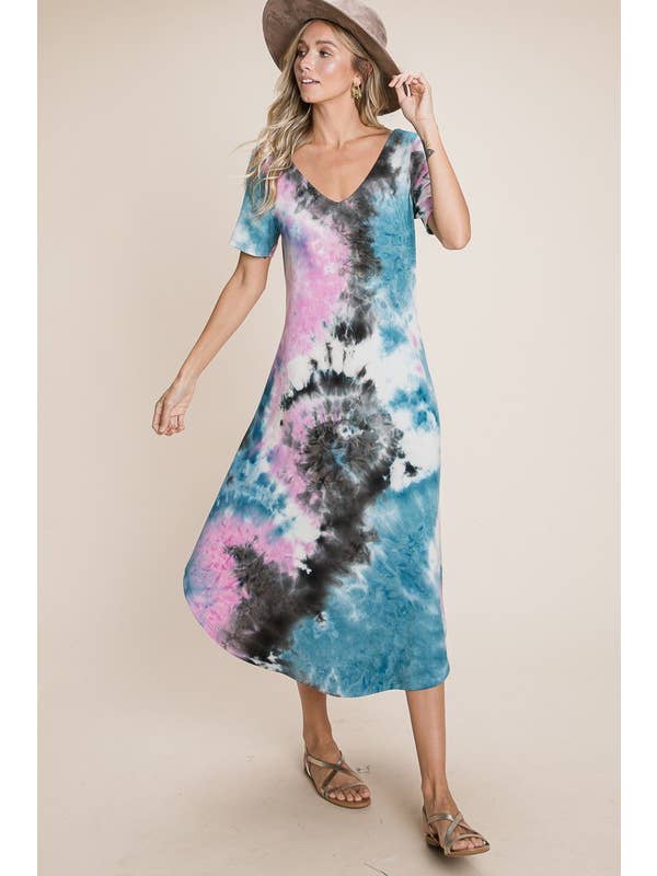 Woman wearing a blue and pink tie-dye V-neck dress with short sleeves and a hat, walking gracefully.