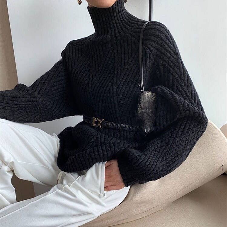 A stylish black turtle neck long sleeve pullover sweater, perfect for any casual outing. The sweater features a unique ribbed pattern and is paired with white trousers for a sophisticated look.