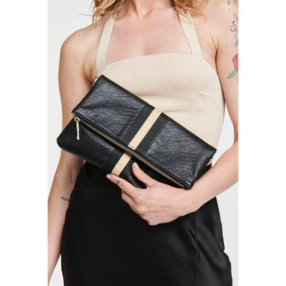 Model holding a black fold-over clutch with a gold stripe, showcasing the bag's elegant design and versatility.