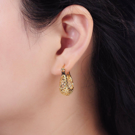 Gold mesh teardrop earrings worn on a woman's ear