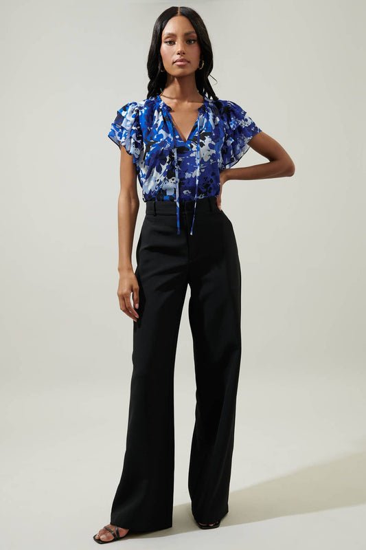 Model wearing the Wide Leg Trousers in black paired with a blue floral blouse, showcasing a stylish and professional outfit.