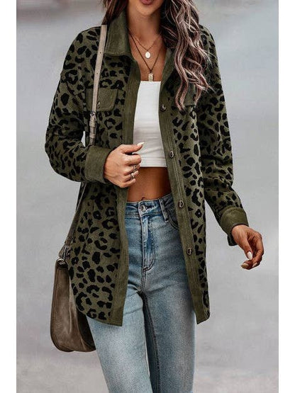 A woman wearing a green leopard print button-down jacket over a white crop top, paired with light-wash jeans and a crossbody bag. The outfit is styled casually with rolled-up sleeves and accessorized with layered necklaces, perfect for a chic, street-style look.