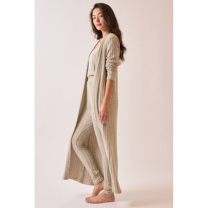 Side view of a soft ribbed long duster cardigan in brushed fabric, styled with matching pieces, featuring a longline silhouette for a cozy and elegant look.