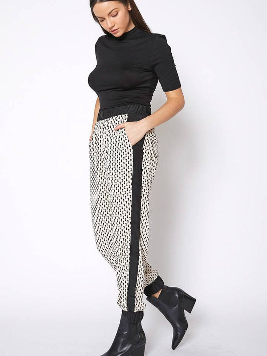 Woman wearing Ro & De Women's Printed Casual Cuffed Hem Pants with a black top and black ankle boots.