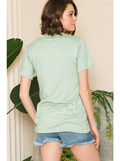 A woman wearing a light green short-sleeve top and denim shorts, viewed from the back.